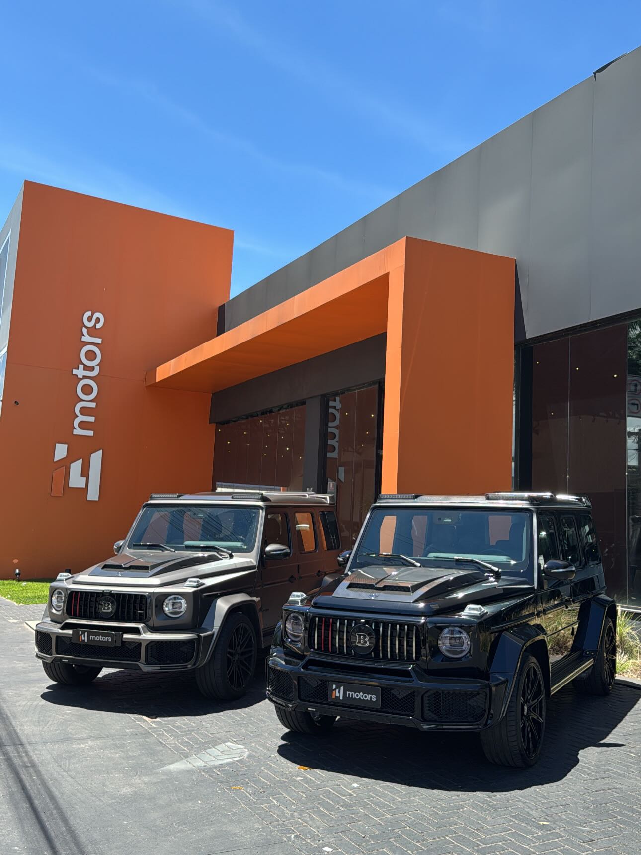 Fachada laranja da I4 Motors com dois veículos especiais